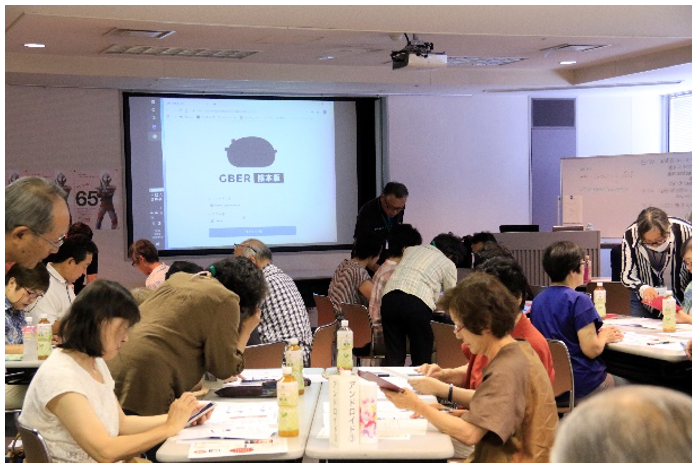 熊本シニアネット講師による夢ネットはちどり会員へのGBER講習会（27名を8グループに分けて9名の講師で対応，グループ内ではiOSもしくはAndroidの利用者を統一）